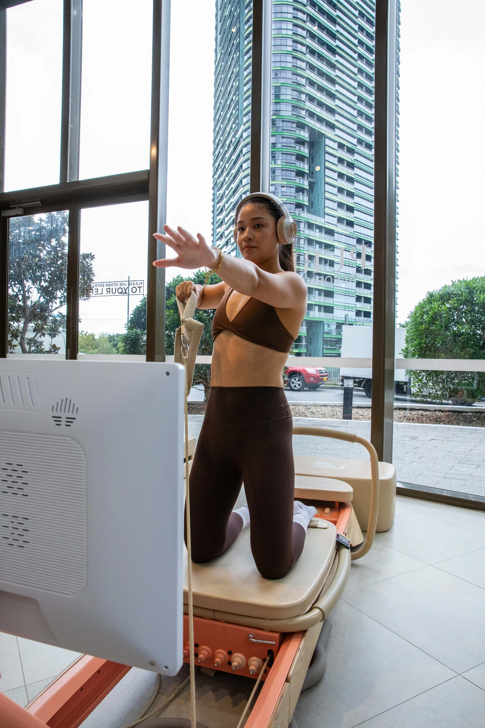 A member working through a session on the reformer in headphones